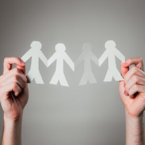 hands holding paper cutout family chain